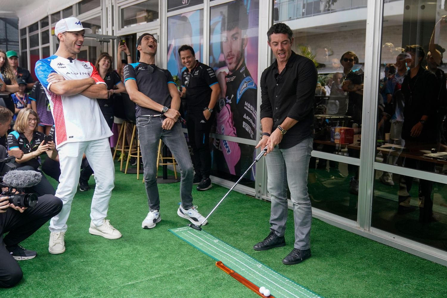 Golfer Rory McIlroy and Alpine drivers Pierre Gasly and Esteban Ocon all react to a missed putt by McIlroy before the sprint race ahead of the Formula One U.S. Grand Prix.
